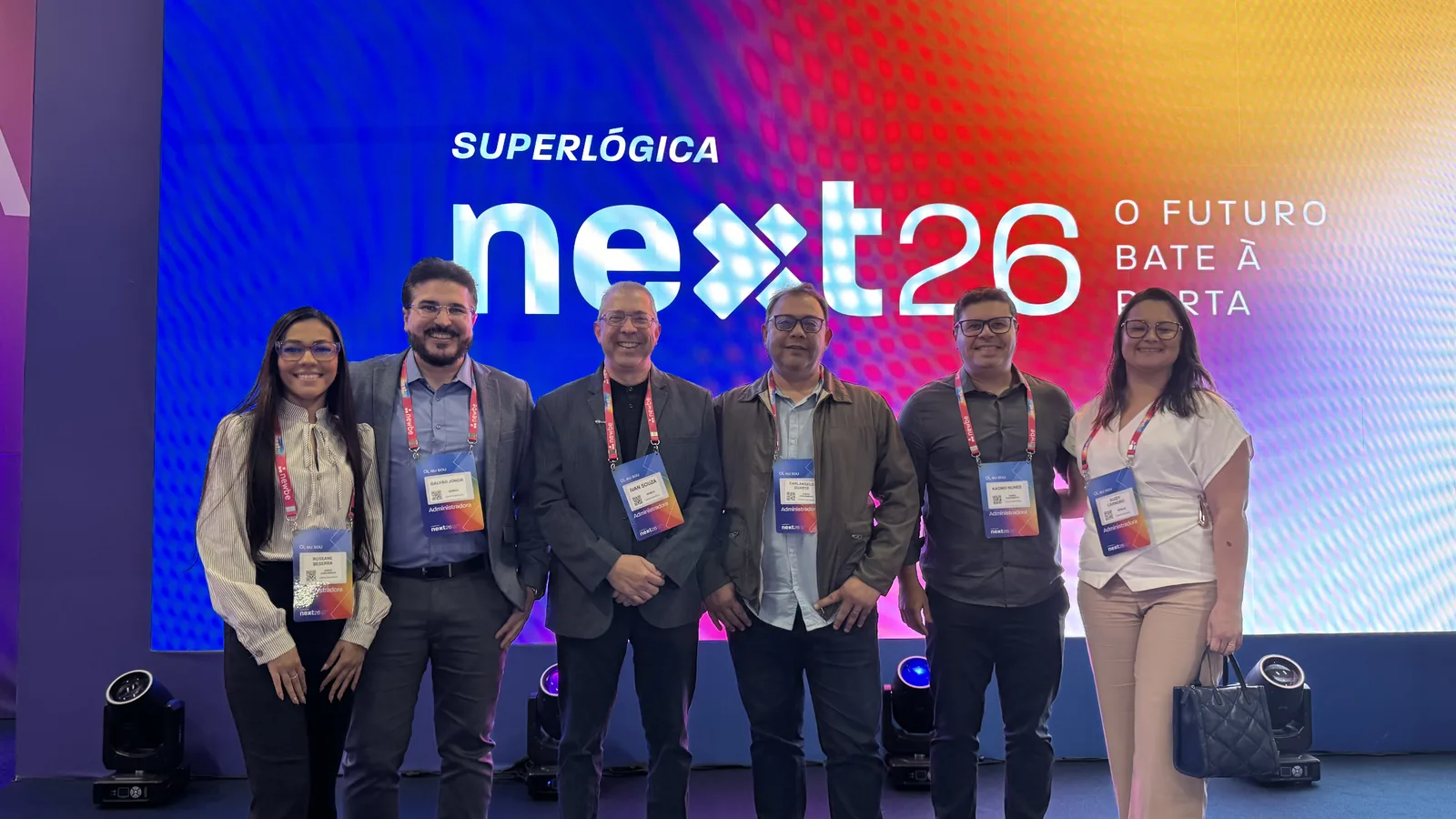 Time da Semog diante do painel do Superlógica Next 2026, com a chamada "O futuro bate à porta"